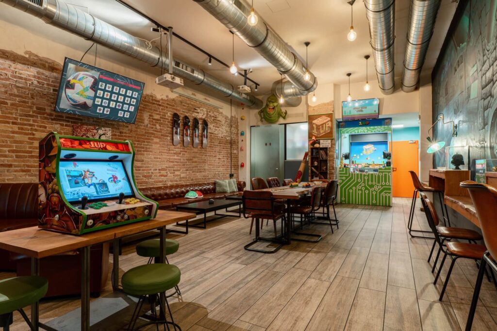 Borne d’arcade et zone lounge du club social 1UP à Barcelone
