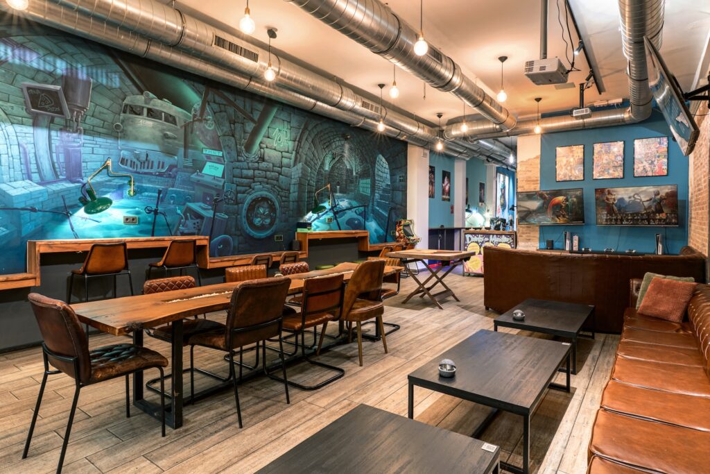 Grande salle du club cannabis 1UP avec une longue table et une fresque style bande dessinée